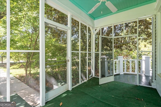 unfurnished sunroom with ceiling fan