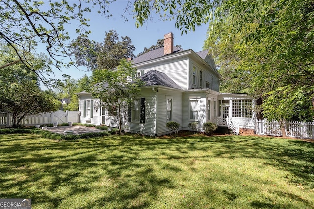 rear view of house featuring a lawn