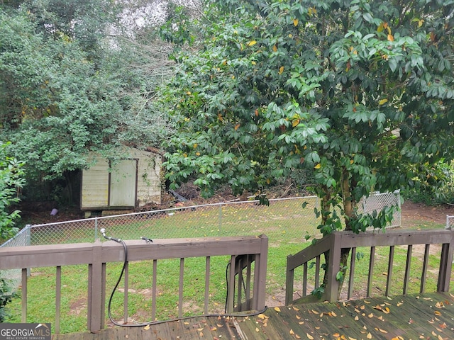 wooden deck with a lawn and a storage shed