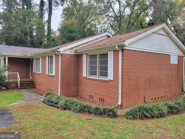 view of side of home with a yard