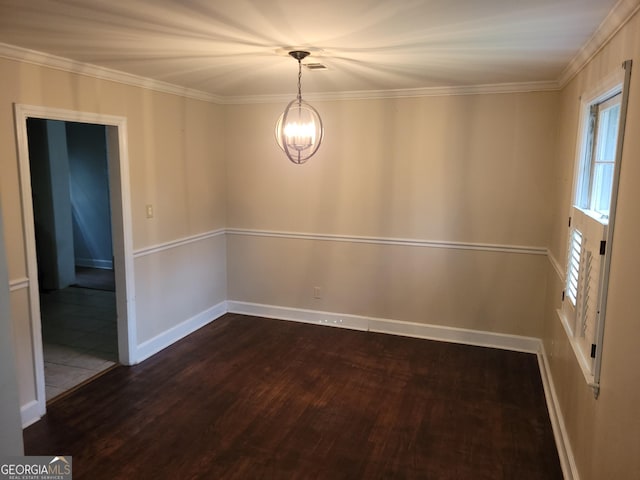 spare room with a notable chandelier, dark hardwood / wood-style floors, and crown molding