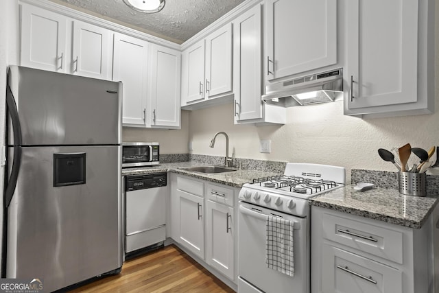 kitchen featuring white cabinets, a textured ceiling, extractor fan, and appliances with stainless steel finishes