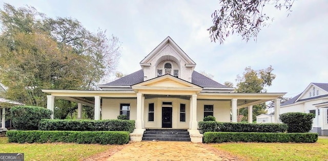 country-style home with a front yard and covered porch