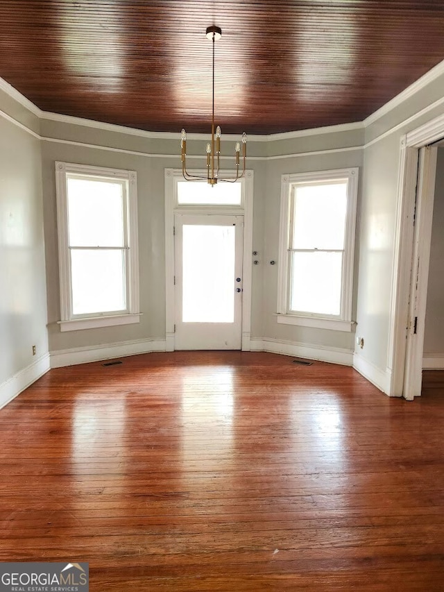 unfurnished dining area featuring hardwood / wood-style flooring, wood ceiling, crown molding, and a notable chandelier