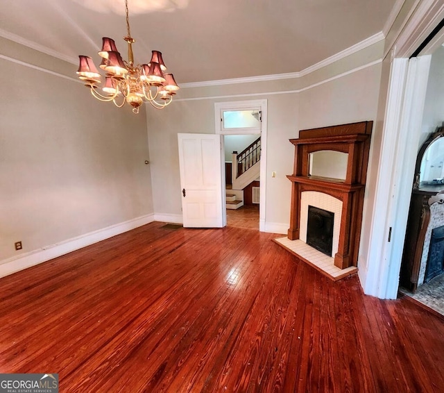 unfurnished living room featuring a brick fireplace, wood-type flooring, a chandelier, and ornamental molding