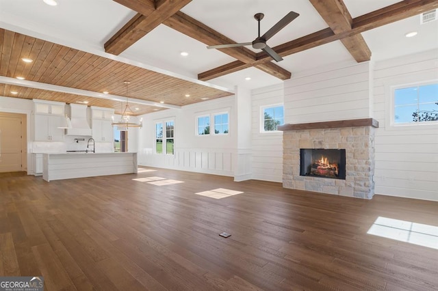 unfurnished living room featuring dark hardwood / wood-style flooring, a fireplace, and beam ceiling