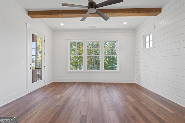 unfurnished room featuring hardwood / wood-style flooring, beamed ceiling, ornamental molding, ceiling fan, and wooden walls