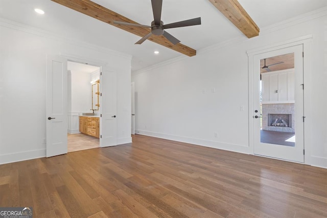 unfurnished bedroom with ensuite bath, beamed ceiling, ceiling fan, and light hardwood / wood-style flooring