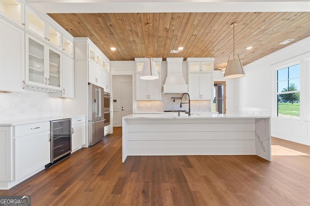 kitchen with pendant lighting, white cabinets, beverage cooler, and wooden ceiling