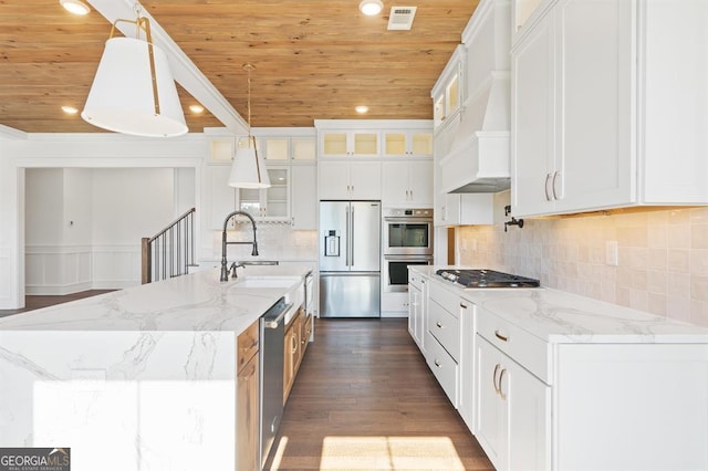 kitchen featuring stainless steel appliances, white cabinetry, and an island with sink