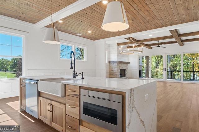 kitchen featuring pendant lighting, stainless steel appliances, dark wood-type flooring, and light stone counters