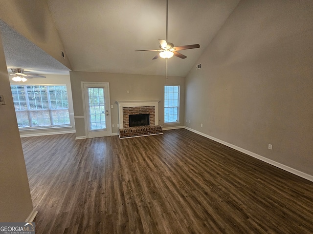 unfurnished living room featuring dark wood-type flooring, high vaulted ceiling, ceiling fan, and a fireplace