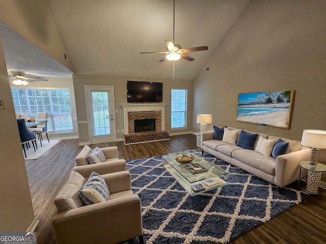 living room featuring visible vents, a brick fireplace, ceiling fan, wood finished floors, and high vaulted ceiling