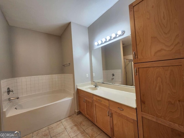 bathroom featuring vanity, tile patterned floors, and a bath