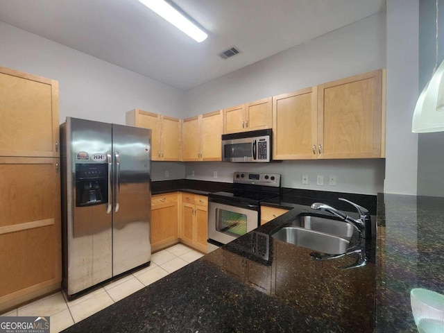 kitchen with light brown cabinets, dark stone countertops, sink, and appliances with stainless steel finishes