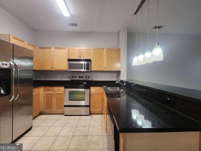 kitchen with stainless steel appliances, hanging light fixtures, dark stone counters, and light tile patterned floors