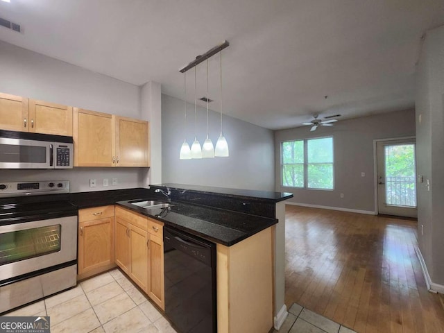 kitchen featuring stainless steel appliances, decorative light fixtures, sink, light hardwood / wood-style floors, and kitchen peninsula