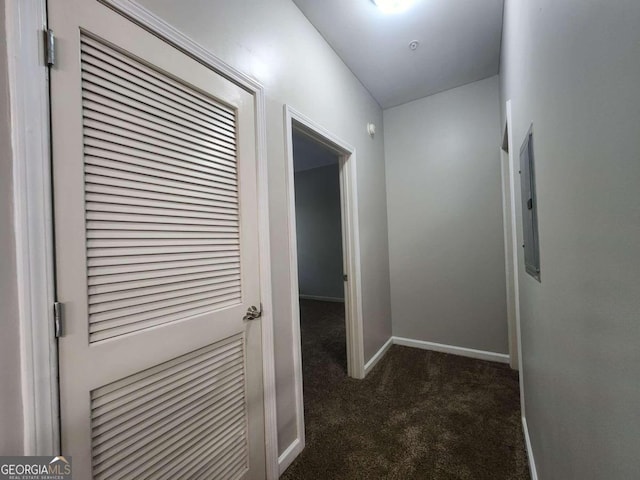 hallway featuring electric panel, dark colored carpet, and vaulted ceiling