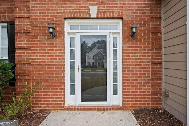 doorway to property with brick siding