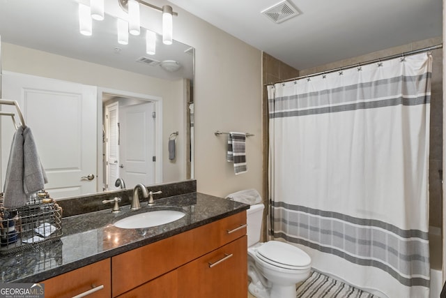 bathroom with curtained shower, vanity, and toilet