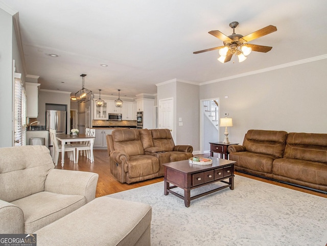 living room featuring wood-type flooring, a wealth of natural light, ceiling fan, and crown molding