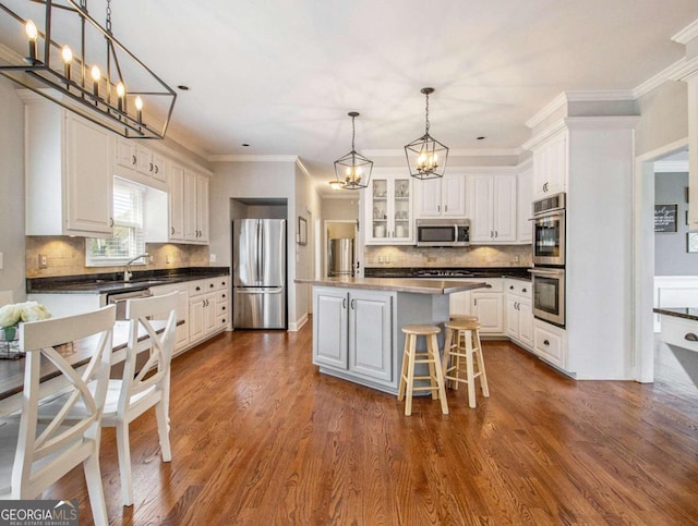 kitchen with a kitchen island, appliances with stainless steel finishes, a breakfast bar, and white cabinets