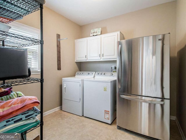 clothes washing area with washer and clothes dryer and cabinets