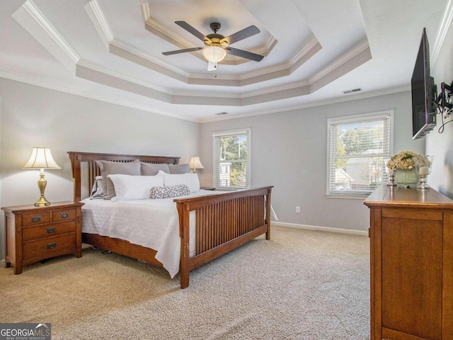 bedroom with crown molding, light carpet, ceiling fan, and a tray ceiling