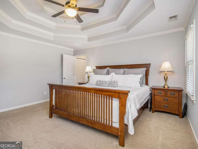 carpeted bedroom with crown molding, ceiling fan, and a tray ceiling