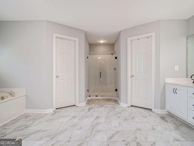 bathroom with vanity and shower with separate bathtub