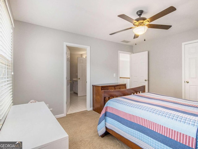 bedroom featuring ensuite bath, light colored carpet, and ceiling fan