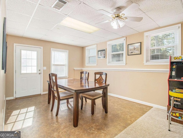 dining room with ceiling fan and a paneled ceiling