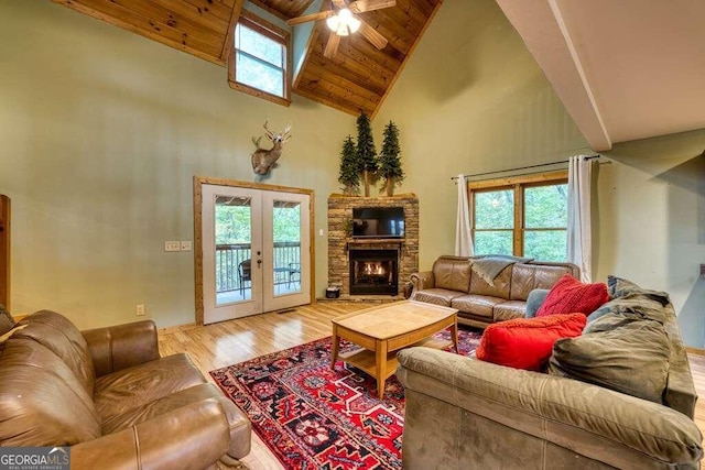 living room with high vaulted ceiling, french doors, a healthy amount of sunlight, and light hardwood / wood-style flooring