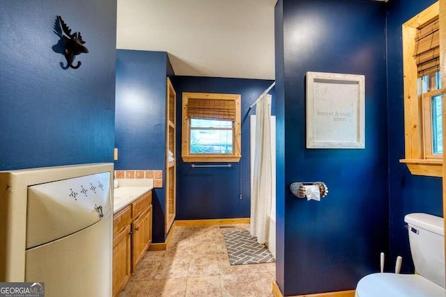 bathroom featuring tile patterned floors, vanity, and toilet