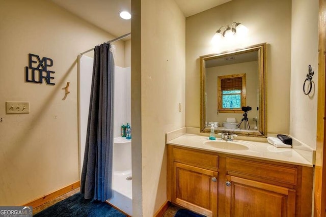 bathroom featuring curtained shower, vanity, and toilet