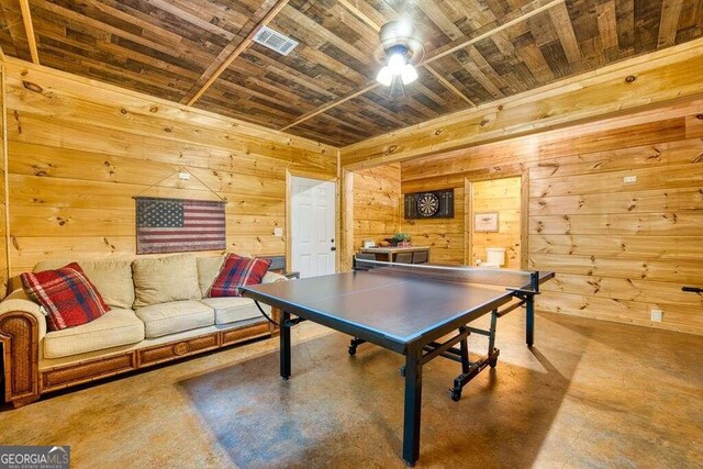 game room with wooden walls, concrete floors, and wooden ceiling