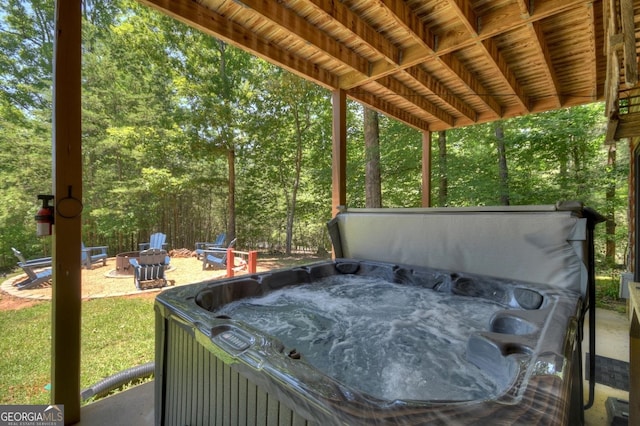 view of patio / terrace featuring a hot tub and a fire pit