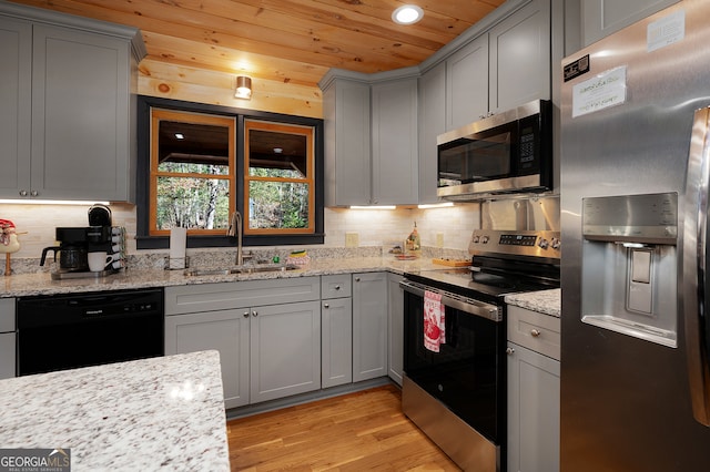 kitchen featuring light stone countertops, appliances with stainless steel finishes, wood ceiling, sink, and light hardwood / wood-style flooring