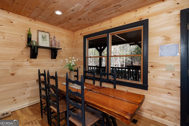 dining area with wooden walls, hardwood / wood-style floors, and wooden ceiling