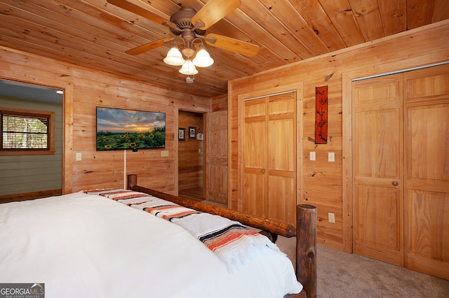 bedroom with carpet floors, ceiling fan, wooden ceiling, and wood walls