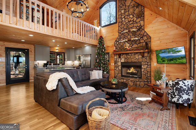 living room featuring high vaulted ceiling, a wealth of natural light, wooden ceiling, and a stone fireplace