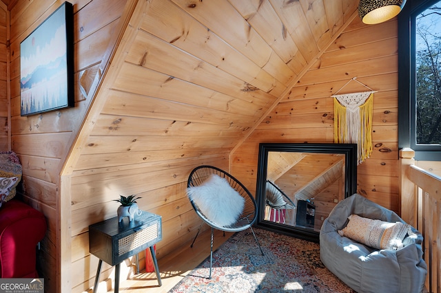 sitting room featuring wood ceiling, wooden walls, and vaulted ceiling