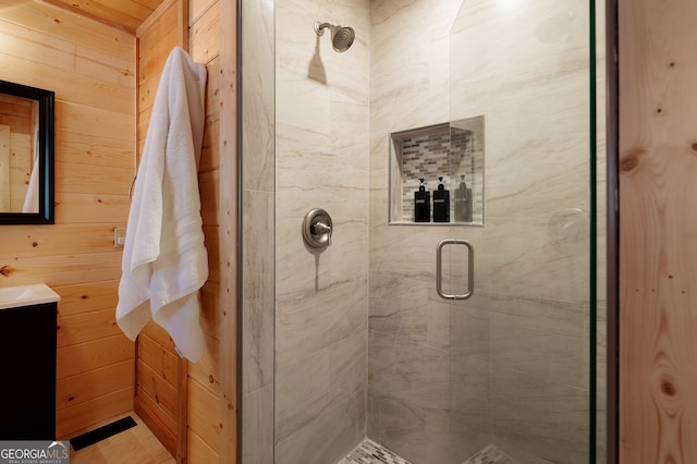 bathroom with wood walls, vanity, and an enclosed shower