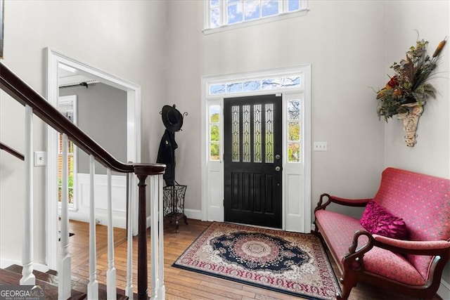 foyer featuring a towering ceiling and hardwood / wood-style floors