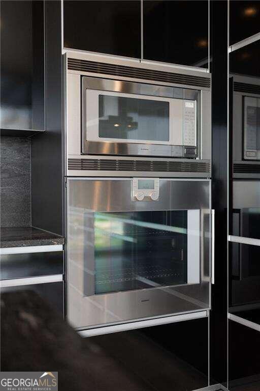 room details featuring tasteful backsplash and stainless steel oven