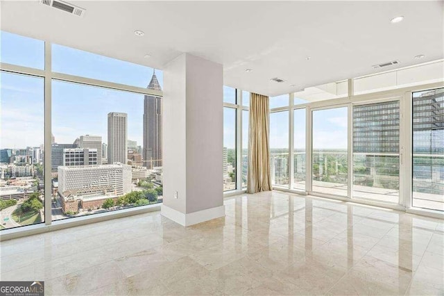 unfurnished room with expansive windows and a healthy amount of sunlight