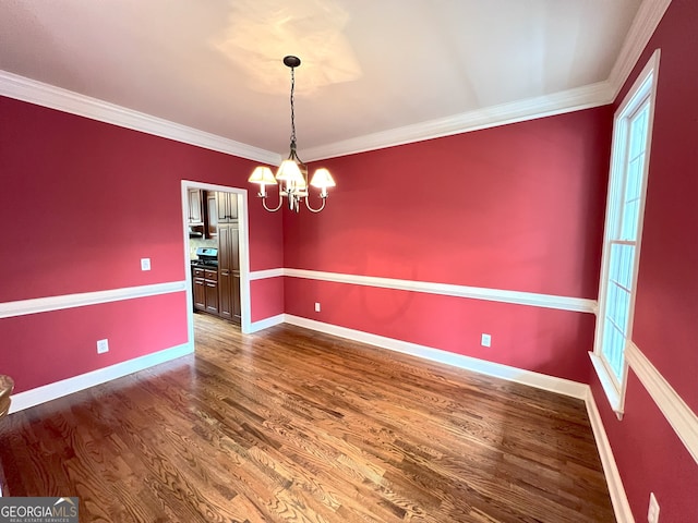 unfurnished dining area featuring hardwood / wood-style floors, a notable chandelier, and ornamental molding