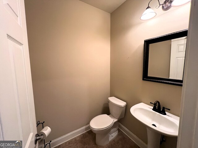 bathroom featuring tile patterned flooring, toilet, and sink