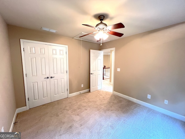 unfurnished bedroom featuring light carpet, a closet, and ceiling fan