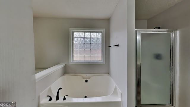 bathroom with a textured ceiling and plus walk in shower